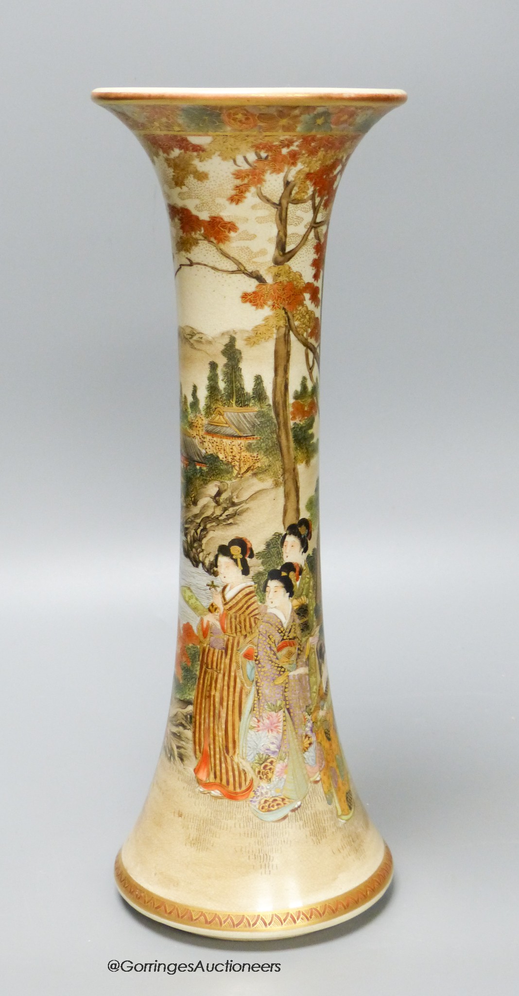 A Japanese satsuma earthenware trumpet vase by Kizan, Meiji period. The body painted and gilt with bijin and children in a lakeside landscape beneath a floral band rim, iron red and gilt signature to base. 30 cm high x 1